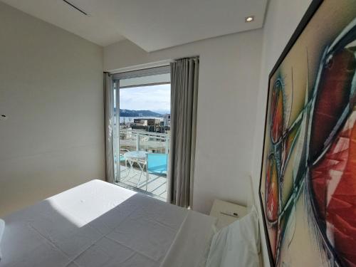 a bedroom with a bed and a window with a view at Book Santos - Unlimited 1709 - Apartamento Vista Mar in Santos