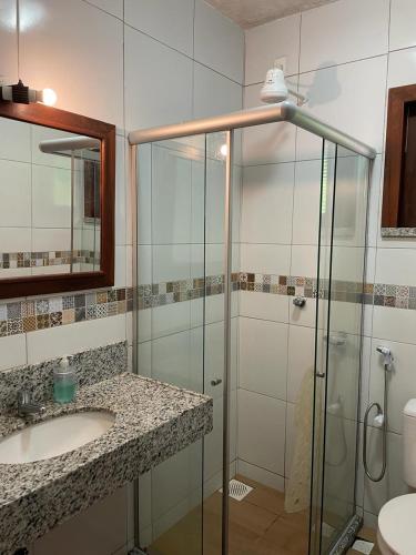 a bathroom with a glass shower and a sink at Guaramiranga Monte Verde in Guaramiranga