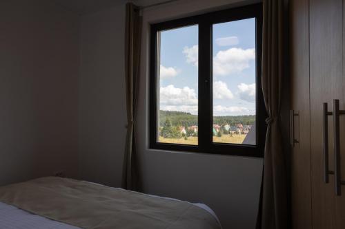 a bedroom with a window with a view of a field at Vila Oaza mira Golija in Golija