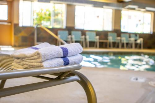 a pile of towels sitting on a bench next to a swimming pool at Red Lion Inn & Suites Vancouver in Vancouver