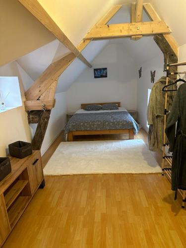 une chambre avec un lit dans un grenier dans l'établissement La maison papillon, à Tonnerre