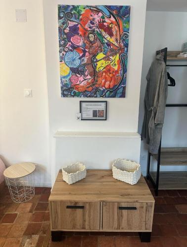 un tableau accroché au mur au-dessus d'une table basse en bois dans l'établissement La maison papillon, à Tonnerre