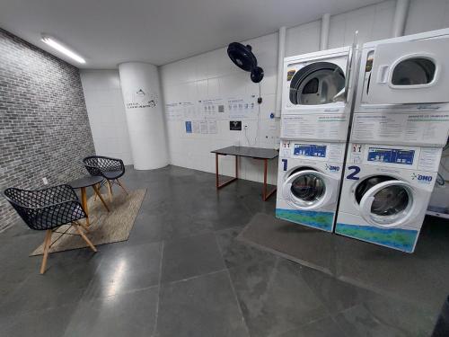 a laundry room with two washing machines and a table at Book Santos - Unlimited 1709 - Apartamento Vista Mar in Santos
