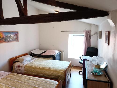 une chambre avec deux lits et une fenêtre dans l'établissement Le grand logis, à Les Sables-dʼOlonne
