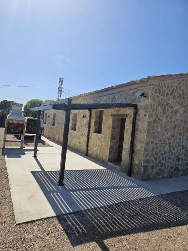 a stone building with a gate and a stone wall at Mas de Melonet Delta del Ebro in L'Aldea