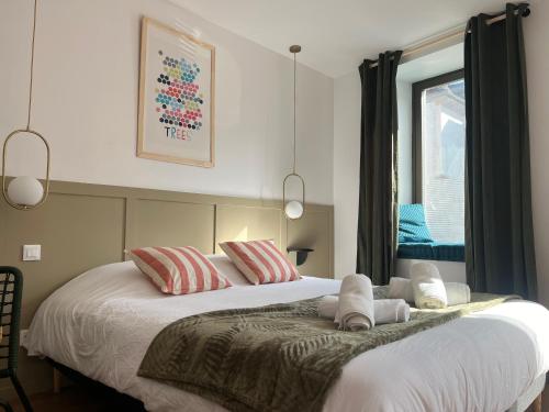 une chambre avec un grand lit blanc avec des oreillers dans l'établissement Studio romantique avec baignoire balnéothérapie duo proche de Colmar et Kaysersberg pour 2 personnes, à Lapoutroie