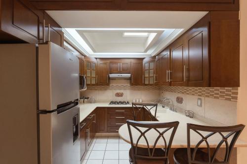 a kitchen with wooden cabinets and a refrigerator at New Apt in Centro GDL Near Cathedral & Attractions in Guadalajara
