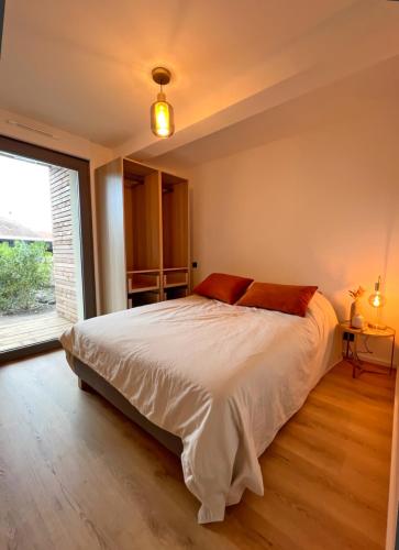 une chambre avec un lit et une grande fenêtre dans l'établissement Premium surf lodge, à Capbreton