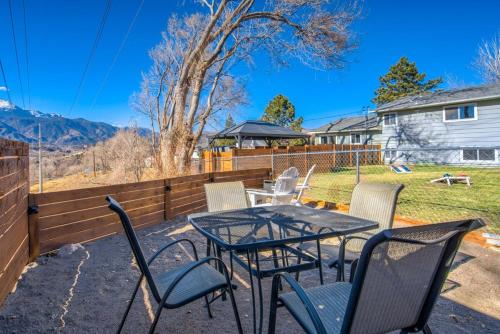 a patio with a table and chairs and a fence at Kings Hideaway Stylish Apartment with Scenic View in Colorado Springs
