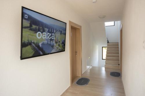 a living room with a flat screen tv on a wall at Vila Oaza mira Golija in Golija