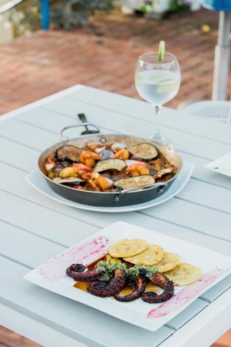 a table with a pan of food and a plate of snacks at Porto Bello Hotel Boutique in Puerto Colombia