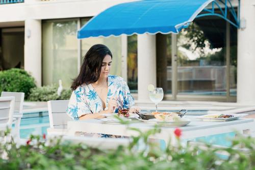 a woman sitting at a table with a plate of food at Porto Bello Hotel Boutique in Puerto Colombia