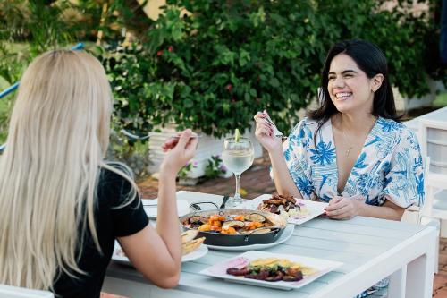 two women sitting at a table eating food at Porto Bello Hotel Boutique in Puerto Colombia