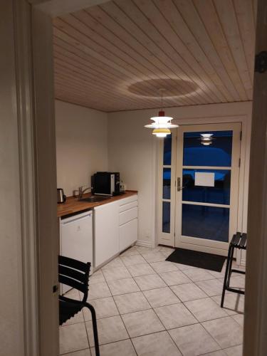 a kitchen with a microwave and a table and chairs at 55retro B&B in Tørring