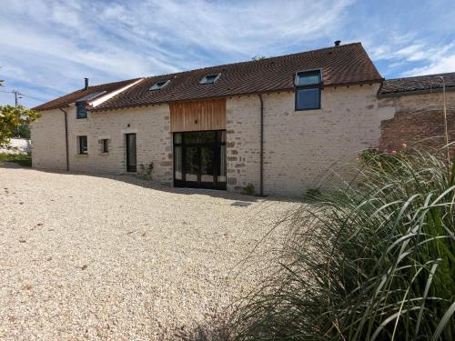 an old brick building on a gravel driveway at Maison familiale avec piscine privée chauffée, près de Pithiviers et Fontainebleau, à 1h30 de Paris - FR-1-590-438 in Puiseaux