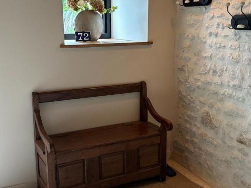 a wooden bench in a room with a window at Maison familiale avec piscine privée chauffée, près de Pithiviers et Fontainebleau, à 1h30 de Paris - FR-1-590-438 in Puiseaux
