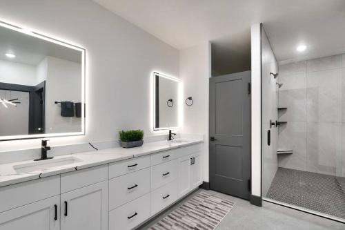 a bathroom with two sinks and a mirror and a shower at Vizcaya #3 - Moab's Newest Luxury Rental - Private Hot Tub in Moab