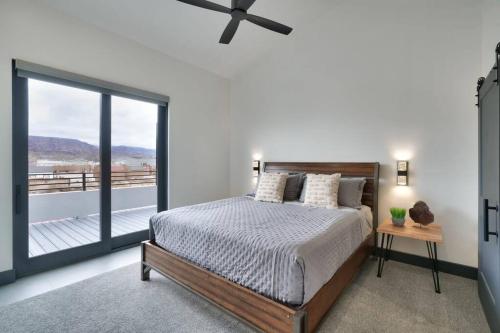 a bedroom with a bed and a large window at Vizcaya #3 - Moab's Newest Luxury Rental - Private Hot Tub in Moab