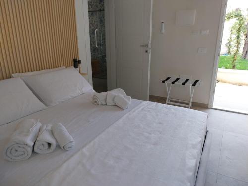 a bedroom with a white bed with towels on it at Luna D'Argento in Leporano Marina