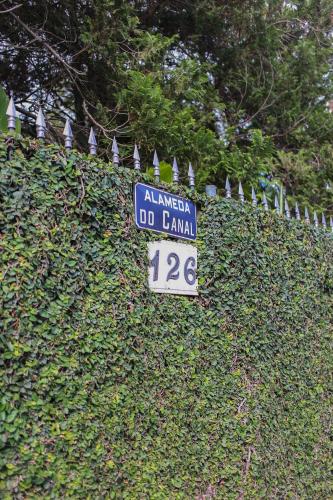 a sign that says aliya do amani on a hedge at Casa com Piscina e Área Gourmet em Mury in Muri