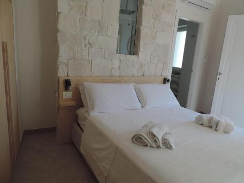 a bedroom with a white bed with towels on it at Luna D'Argento in Leporano Marina