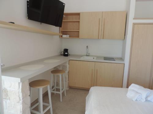 a small room with a bed and a kitchen with a counter at Luna D'Argento in Leporano Marina