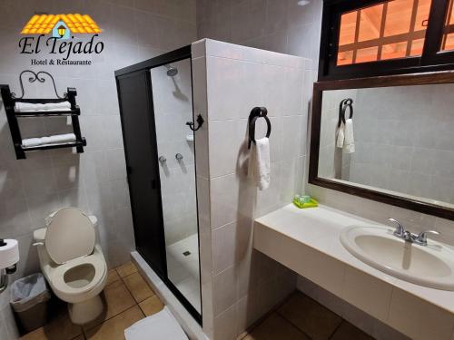a bathroom with a toilet and a sink and a shower at El Tejado in Suchitoto