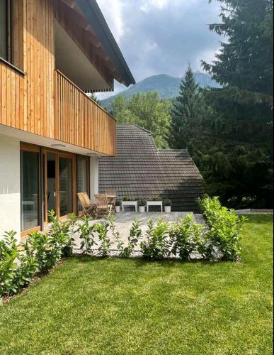 un patio di una casa con prato di Apartma Gorna a Kranjska Gora