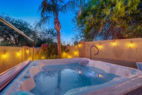 a swimming pool in a backyard at night with lights at Kiva Cove Pool & Sun Loungers on the Patio in Mesa