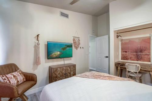 a bedroom with a bed and a chair and a window at Kiva Cove Pool & Sun Loungers on the Patio in Mesa