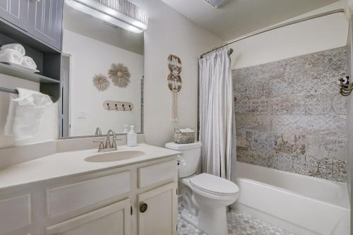 a white bathroom with a sink and a toilet at Kiva Cove Pool & Sun Loungers on the Patio in Mesa