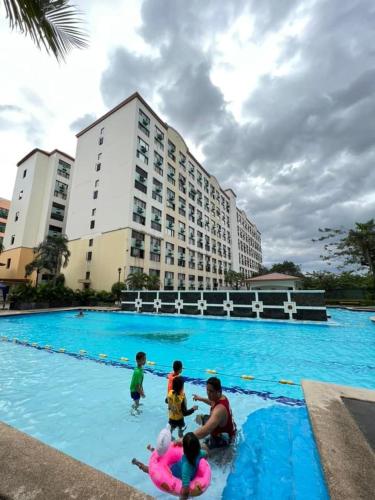a group of people playing in a swimming pool at Twins staycation by wench in Cambridge condo in Cainta