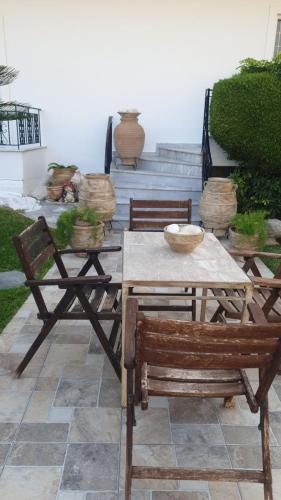 a wooden table and two chairs and a table and a table and chairs at Garden House in Amarinthos