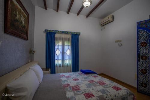 a bedroom with a bed with a quilt on it at casa yasminna in Chefchaouene