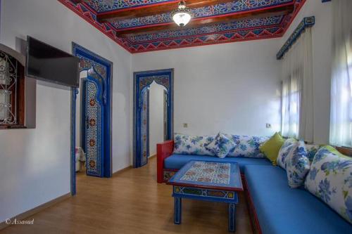 a living room with a blue couch and a table at casa yasminna in Chefchaouene