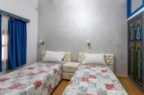 a bedroom with two beds and a couch in it at casa yasminna in Chefchaouene