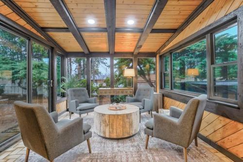 a room with chairs and a table and windows at Pinewood Meadow & Scenic Hot Tub & BBQ & Outdoors in Colorado Springs