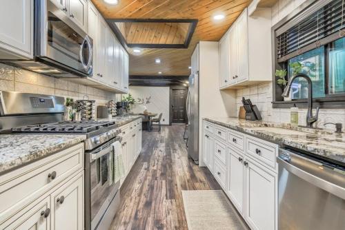 a large kitchen with white cabinets and wooden floors at Pinewood Meadow & Scenic Hot Tub & BBQ & Outdoors in Colorado Springs
