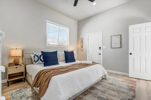 a bedroom with a bed with blue pillows and a window at Pinewood Sanctuary Secluded & Peaceful OCC Oasis in Colorado Springs