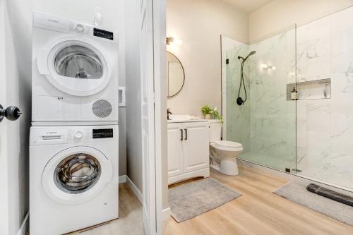 a bathroom with a washer and dryer next to a toilet at Pinewood Sanctuary Secluded & Peaceful OCC Oasis in Colorado Springs