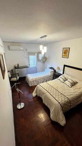 a bedroom with two beds and a desk with a lamp at Temporarios en Avellaneda Centro in Avellaneda