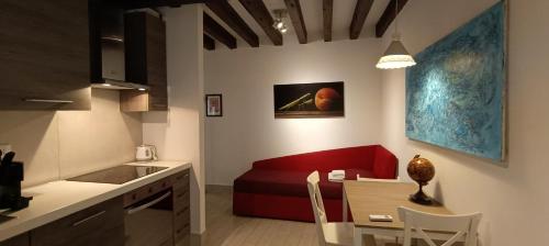 a kitchen and a living room with a red couch at Ca Del Gambero Canal View in Venice