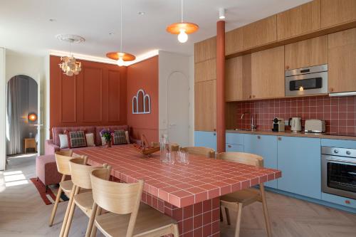 une cuisine avec une table et des chaises dans une pièce dans l'établissement New Flat Terracotta Style - Greater Paris district, à Malakoff