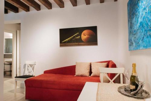 a living room with a red couch and a table at Ca Del Gambero Canal View in Venice