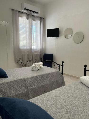 a bedroom with two beds and a tv on the wall at Marisol in Marsala