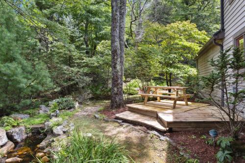 a wooden bench sitting on a deck next to a house at Ridgeline Views in Boone