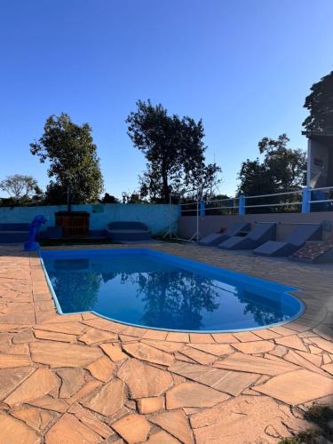 a small swimming pool on a brick patio at Pousada Sitio Roda D'Água Mairinque in Mairinque