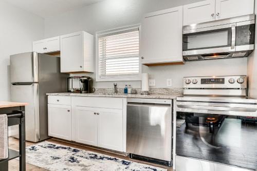 a kitchen with white cabinets and stainless steel appliances at Charming Helen Vacation Rental 2 Mi to Village! in Helen