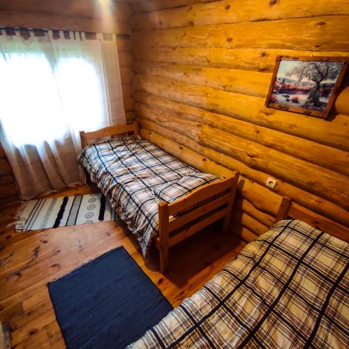 a room with two beds in a log cabin at Lambievi Kolibi in Gorno Kraishte