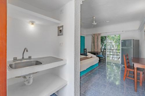 une salle de bain avec un lavabo et une chambre avec un lit dans l'établissement Mayan Art Hotel a unos pasos de la 5a Avenida, à Playa del Carmen